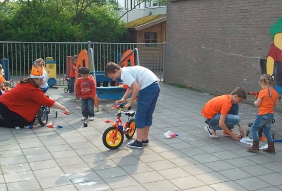 Mooi voorbeeld van integratie op een IKC: leerlingen groep 8 helpen peuters fietsen versieren